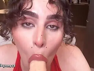 Una bella ragazza trans dai capelli ricci fa del suo meglio per fare un pompino profondo